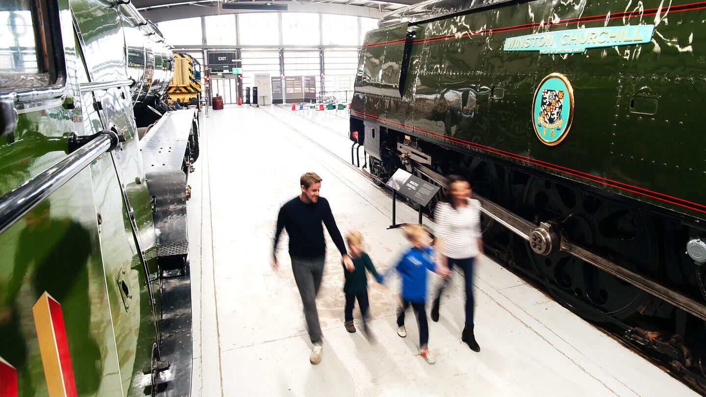 Family looking at locomotives on display in museum