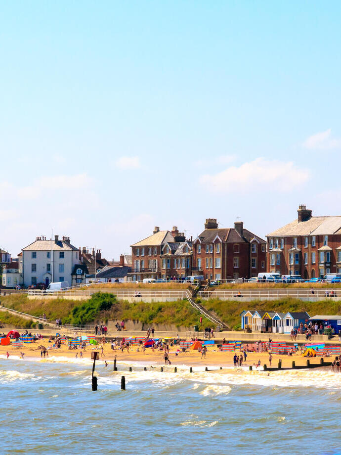 Beach with seaside cottages, beach huts and a lighthouse