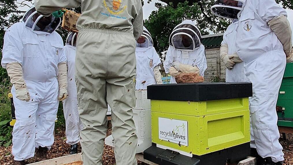 Un gruppo di persone vestite con costumi da apicoltori al Bee Centre