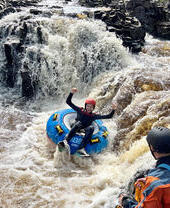 Eine Frau beim Rafting auf Stromschnellen im Endless Adventure North East in Newcastle
