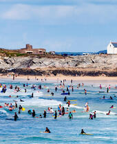 Surfers at Fistral beach in Newquay, Cornwall, England