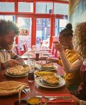 Two men and a woman eating in a restaurant