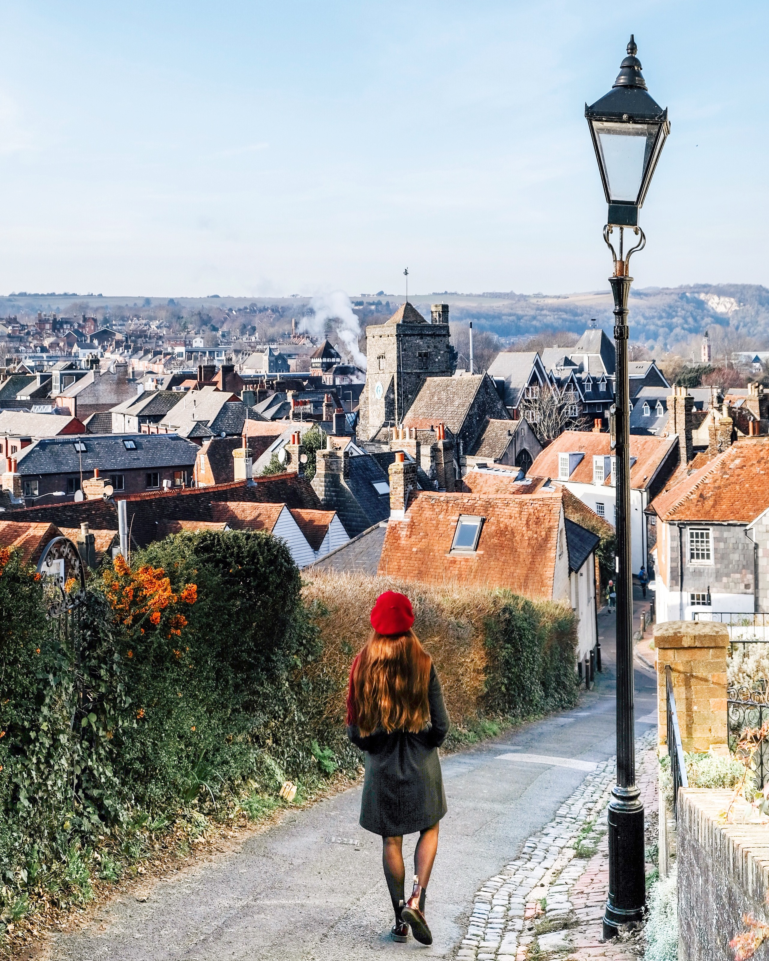 Girl looking down a countryside road to a village below
