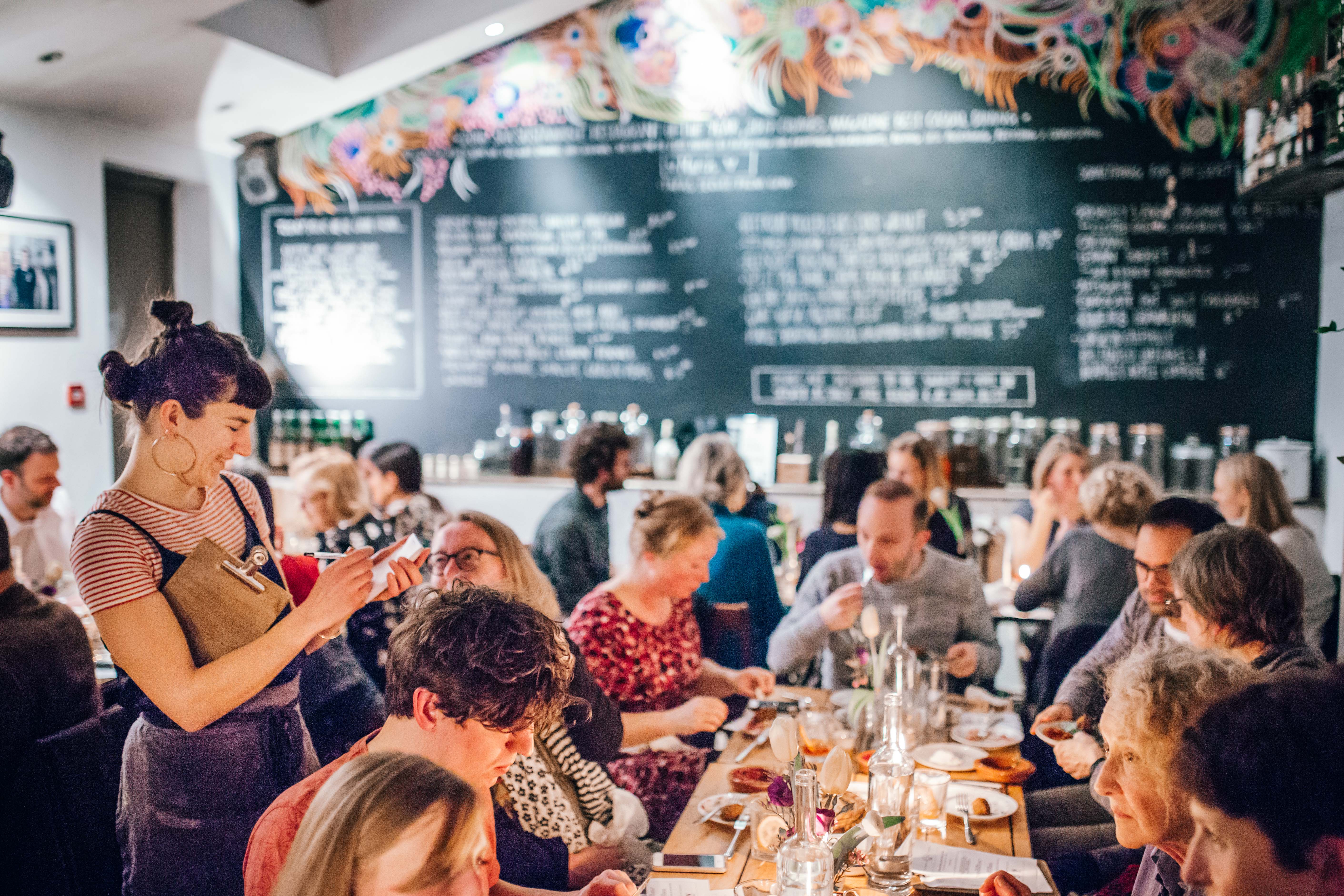 مجموعة من الأشخاص يتناولون الطعام على طاولة في بوكوس تاباس بار، بريستول