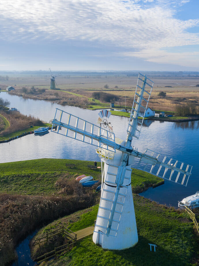 Luftaufnahme einer Windmühle und der umliegenden Weiden und Kanäle