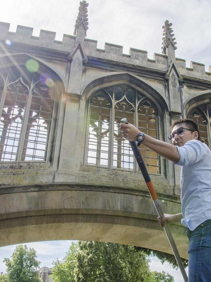 Low angle view of adult man punting beneath a bridge