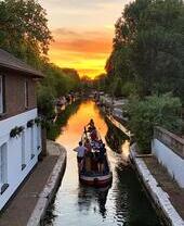 Personas en una barcaza en un canal al atardecer