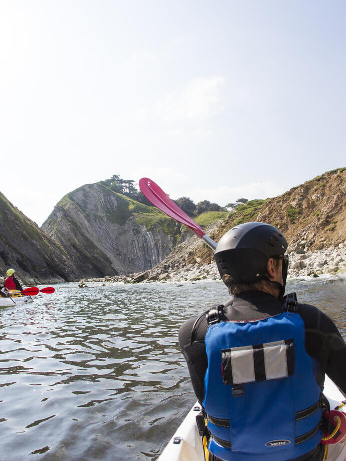 People kayaking along the shores of coastline