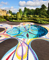 Ground pool sculpture in the landscape at Jupiter Artland with house and topiary gardens in distance