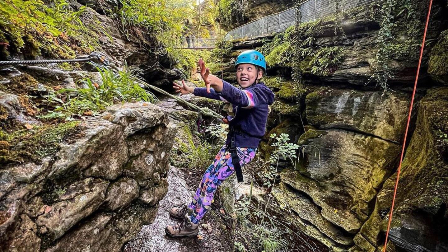 Un enfant suspendu à une corde lors d'une aventure dans les Yorkshire Dales.
