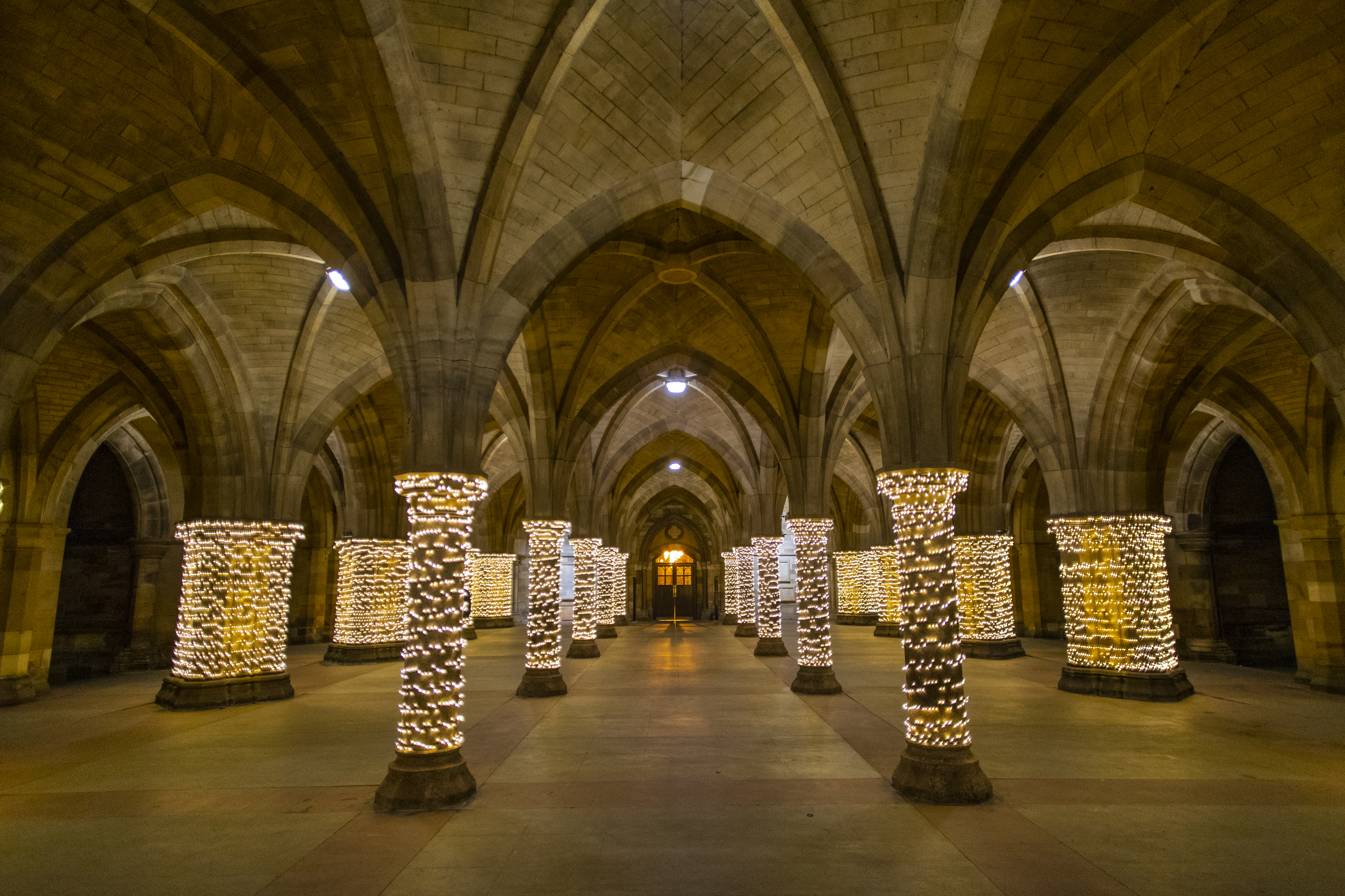 Fairy lights wrapped around pillars in a cloister