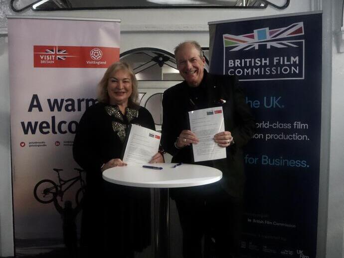 Patricia Yates, directora general de VisitBritain, y Adrian Wootton OBE, director ejecutivo de la British Film Commission, firman un memorando de entendimiento en FOCUS London