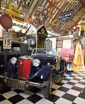 Coches, motos y carteles antiguos expuestos en un museo